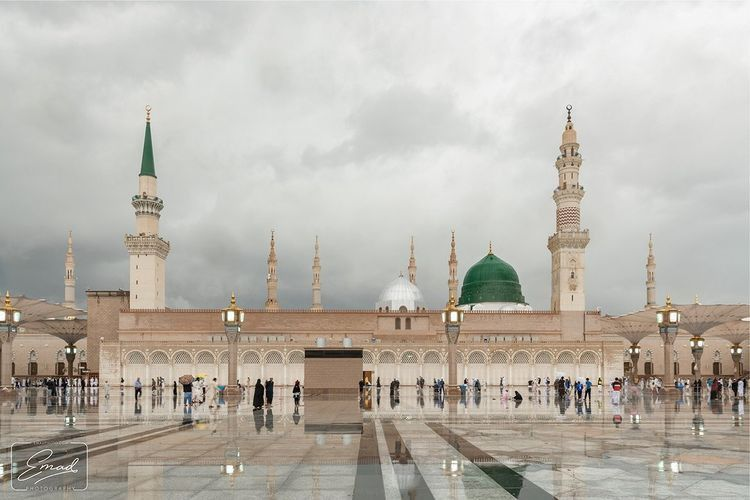 The plaza of Masjid an-Nabawi in Madinah with the Green Dome and minarets under an overcast sky